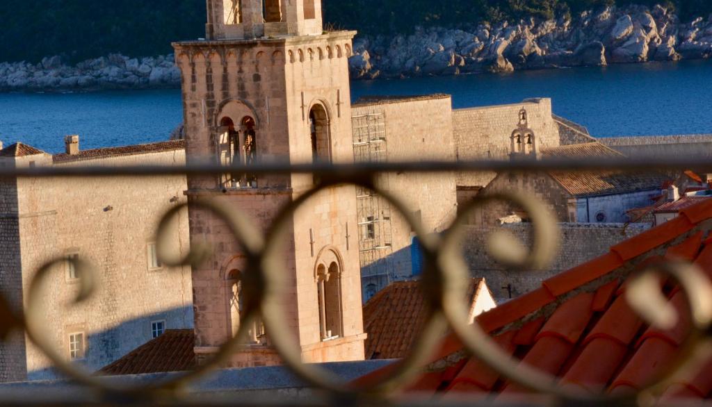 un edificio con una torre de reloj detrás de una valla en boutique Villa Dorma, en Dubrovnik