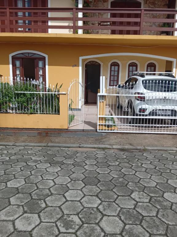 un coche blanco estacionado frente a una casa en Casa no Campeche em ambiente familiar, en Florianópolis