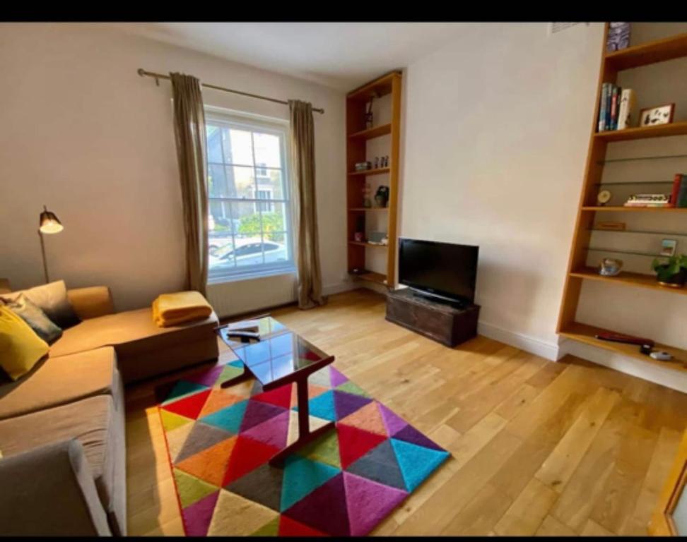 倫敦的住宿－Fab location 2 bed garden flat camden，客厅配有沙发和色彩缤纷的地毯