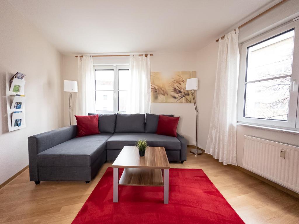uma sala de estar com um sofá e um tapete vermelho em Ambiente-Wohnung - Zentrum und Park in 5 Minuten zu Fuß - Parkplatz - Netflix em Leipzig