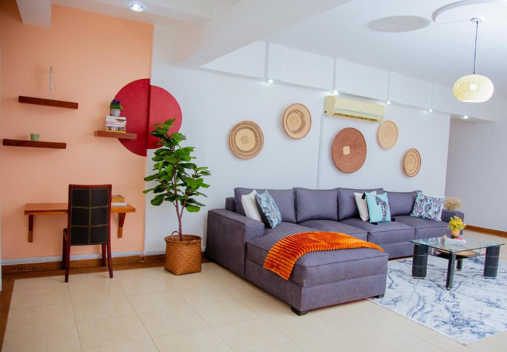 een woonkamer met een blauwe bank en een tafel bij The Notch in Dar es Salaam