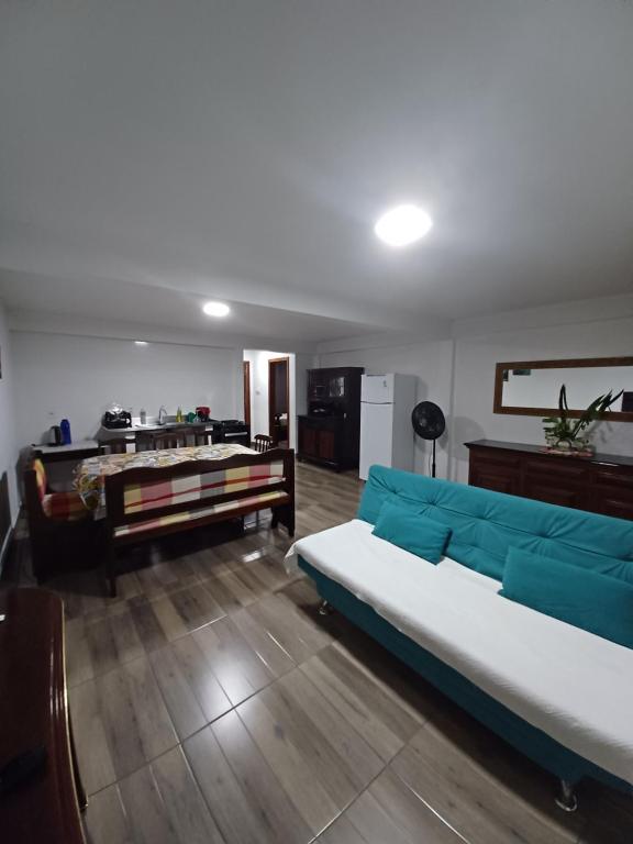 een woonkamer met een blauwe bank en een tafel bij Apartamento em chácara com piscina próximo de praias com internet in São Francisco do Sul