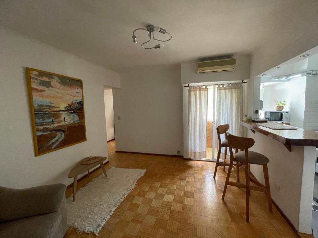 uma sala de estar com uma cozinha com um balcão e cadeiras em El 10 de Telmo em Buenos Aires
