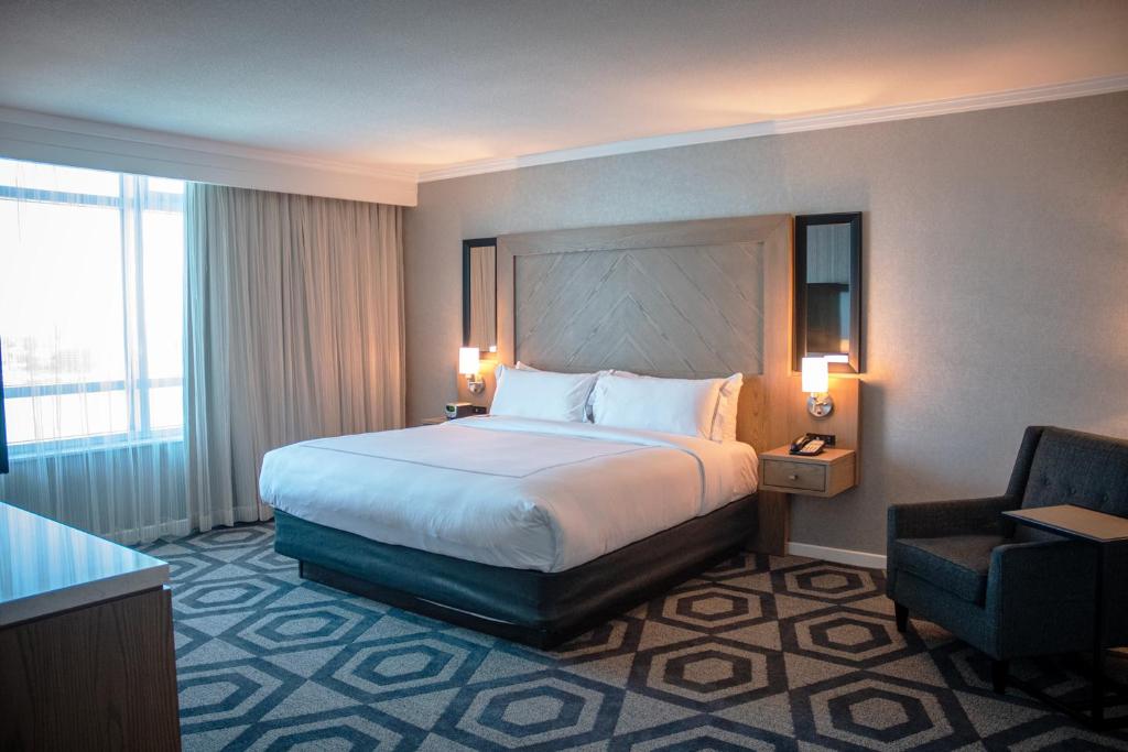 a hotel room with a bed and a chair at Caesars Windsor Hotel and Casino in Windsor