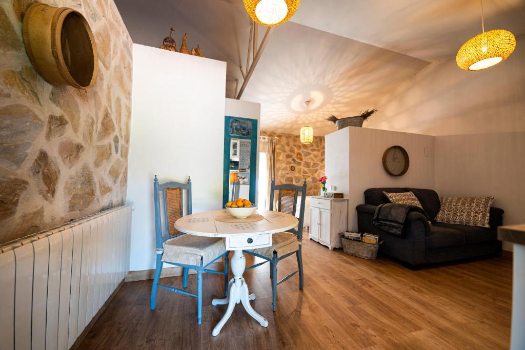 ein Wohnzimmer mit einem Tisch und einem Sofa in der Unterkunft Finca MOLINO DE JARANDA - Oropéndolas in Collado