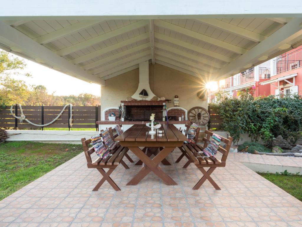 a wooden picnic table with chairs on a patio at Euphoria Country House in Agios Ioannis