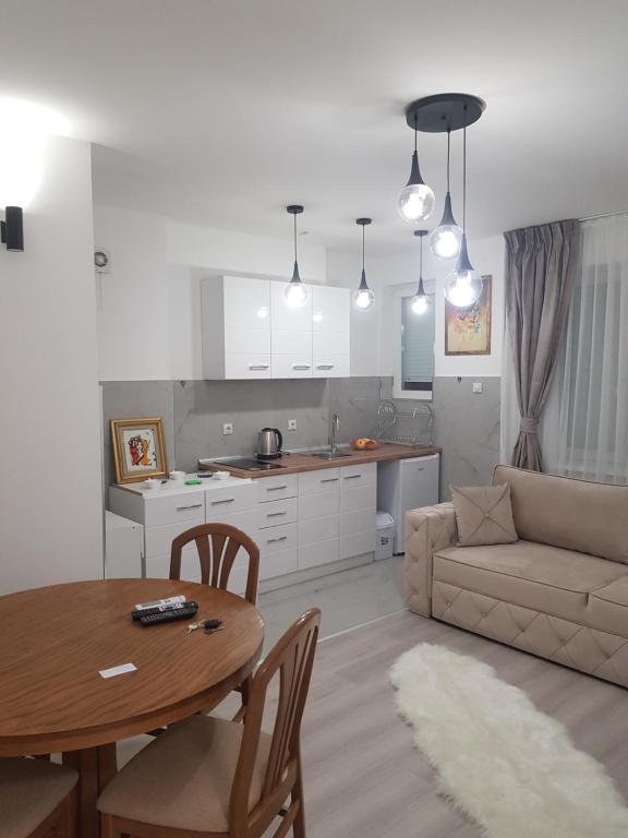 eine Küche und ein Wohnzimmer mit einem Tisch und einer Couch in der Unterkunft City Diamond Apartment in Skopje