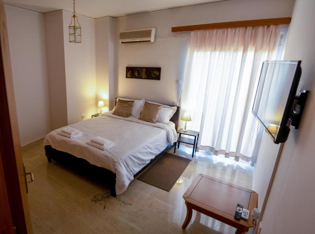 a bedroom with a bed and a flat screen tv at CityCenter Apartment in Missolonghi