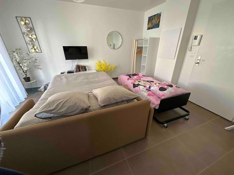 - une chambre avec un grand lit et un miroir dans l'établissement Proche Disney et Paris - Studio terrasse et parking privé, à Montévrain