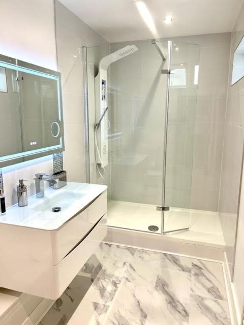 a white bathroom with a shower and a sink at The Quay in Newhaven