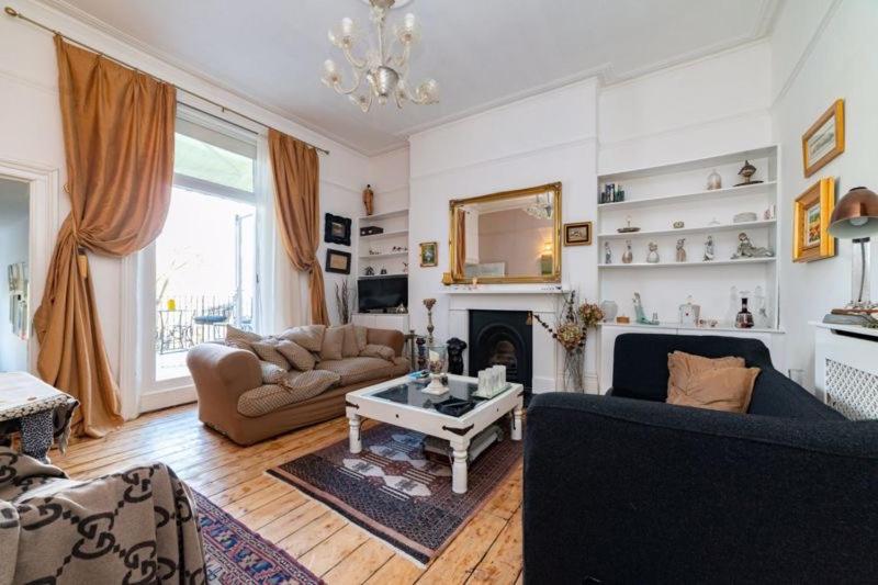 a living room with a couch and a fireplace at Elgin Terrace in London
