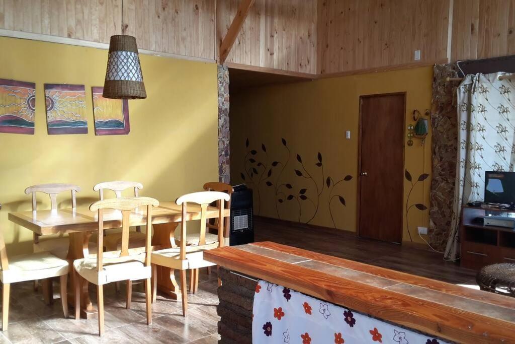 a dining room with a wooden table and chairs at Arriendo Casa Pichidangui in Los Vilos
