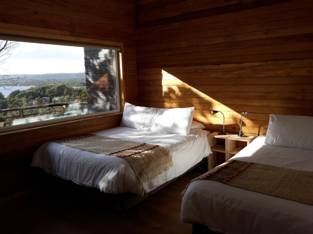 Postel nebo postele na pokoji v ubytování Huillín Lodge