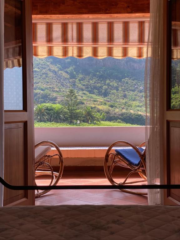 ein Zimmer mit zwei Stühlen vor einem Fenster in der Unterkunft CASA LA ROSA in Leni