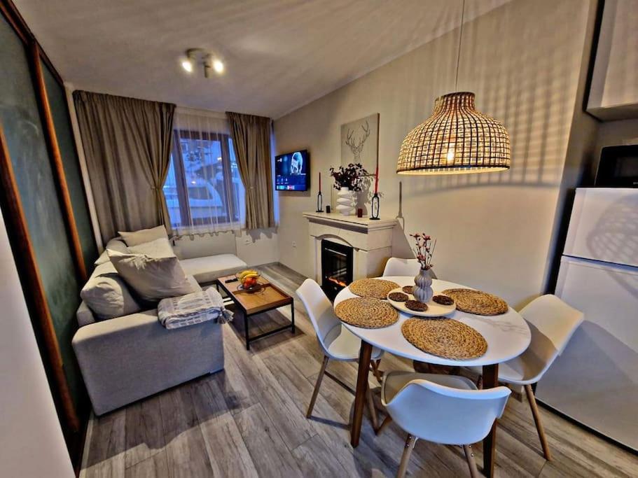 a living room with a table and a couch at 1 bedroom luxury apartment Milena -free parking in Pamporovo