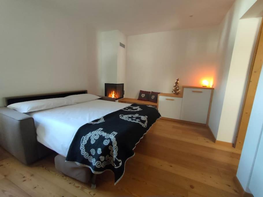 1 dormitorio con 1 cama grande con manta blanca y negra en Happy Bolbeno House CIPAT: 022239-AT-814829, en Saone