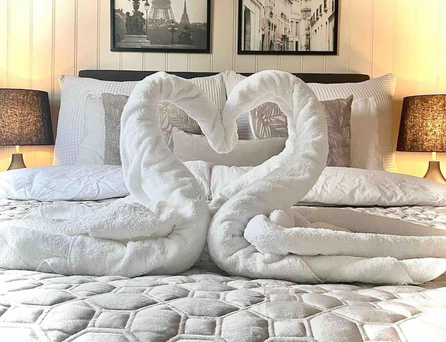 uma cama com dois cisnes feitos de lençóis brancos em Bratsberg Apartment - with Kitchenette and Free Parking em Trondheim