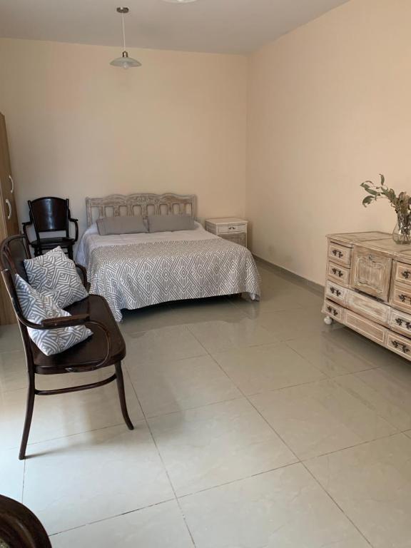 1 dormitorio con cama, silla y vestidor en Mono ambiente Macarena en San Juan