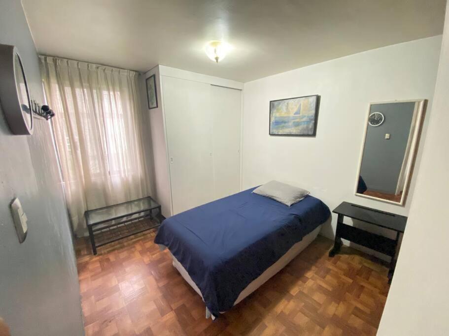a bedroom with a bed and a mirror and a table at Lovely Depa. Forosol Palacio Airport 10 Min in Mexico City