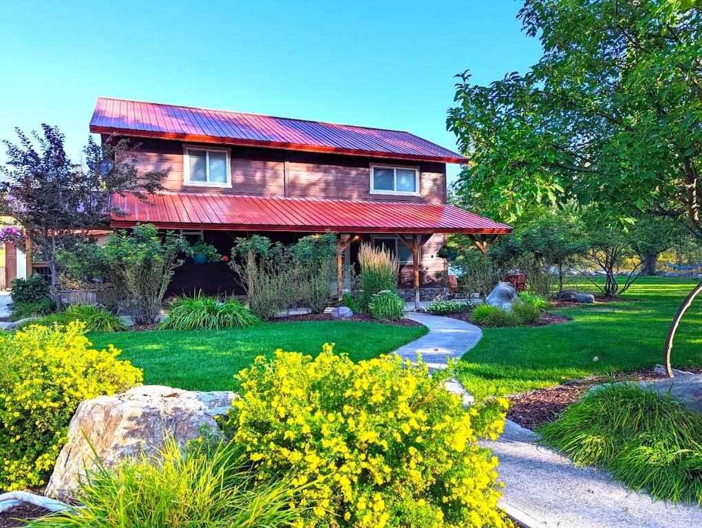 ein Haus mit einem roten Dach und einem Garten in der Unterkunft Tall Timbers Cabin in West Glacier
