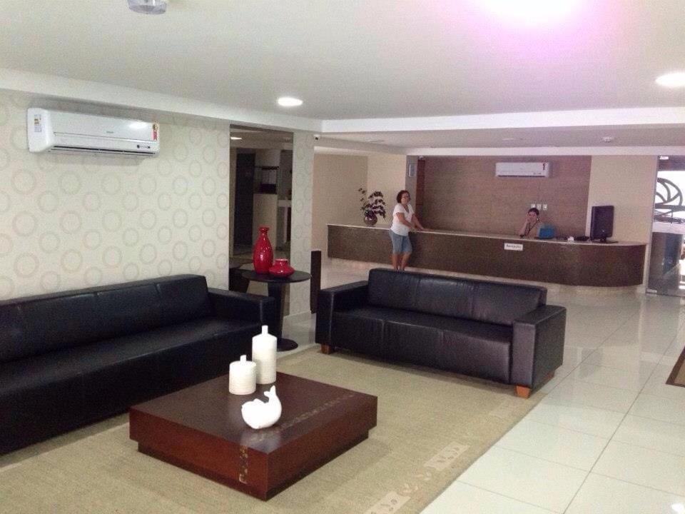 una mujer está de pie en una sala de estar en Flat com varanda beira-mar, en João Pessoa