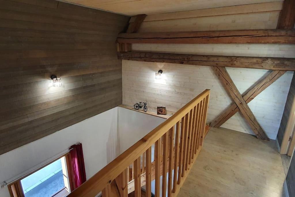 Schody na poddaszu w domu z drewnianymi belkami stropowymi w obiekcie Grand appartement neuf avec parking gratuit. w mieście Malbuisson