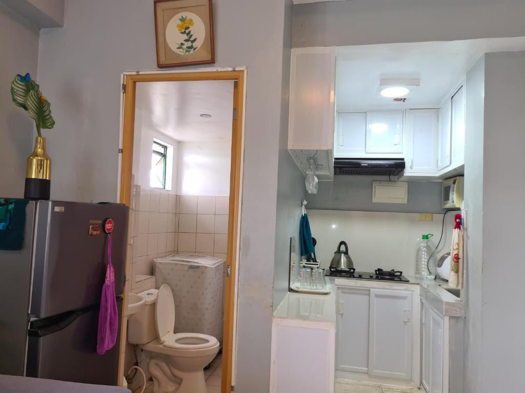 a small kitchen with a refrigerator and a toilet at Budget Friendly Transient in Cainta in Cainta