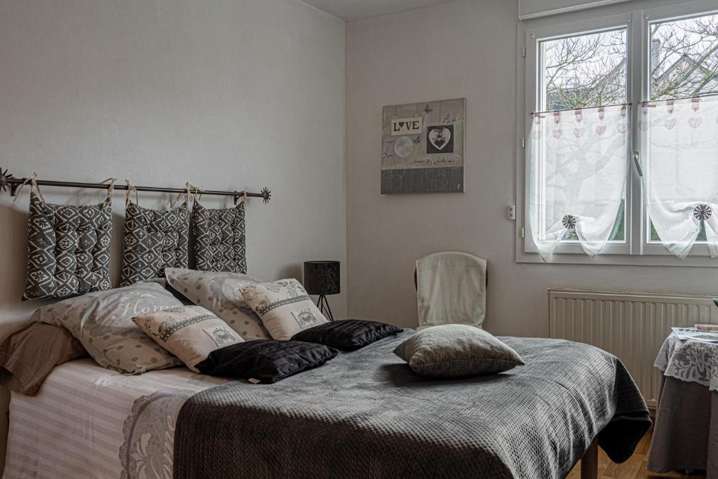 a bedroom with a bed with pillows on it at chambres d hotes les papillons in Évron