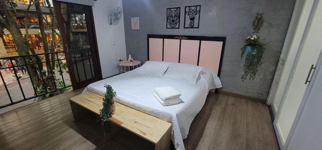een slaapkamer met een groot wit bed en een tafel bij San Antonio in Medellín