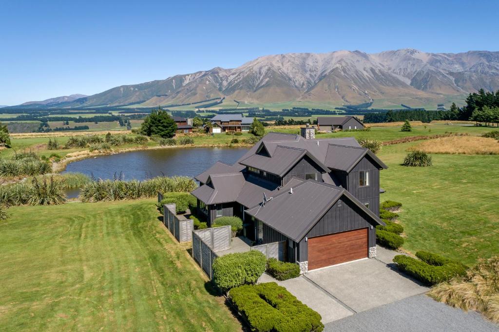 an aerial view of a house with a lake and mountains at Yuki's Chalet - Terrace Downs in Windwhistle