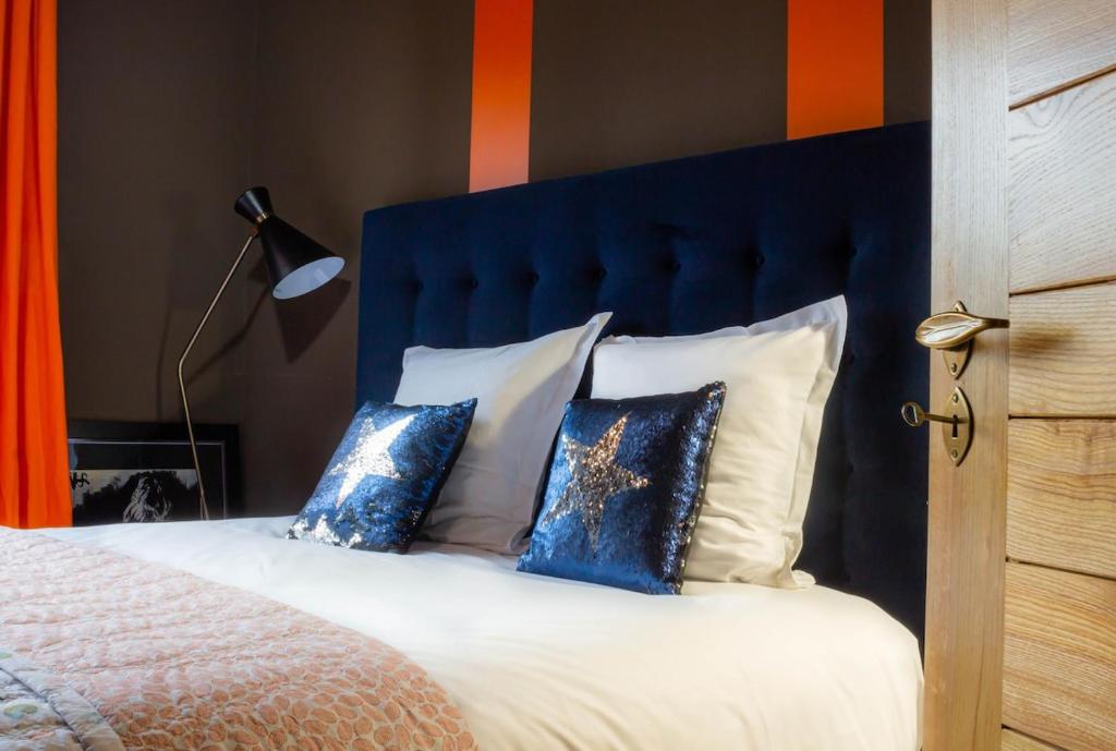 - un lit avec une tête de lit et des oreillers bleus dans l'établissement Petit Palace vue sur Imperial, à Annecy