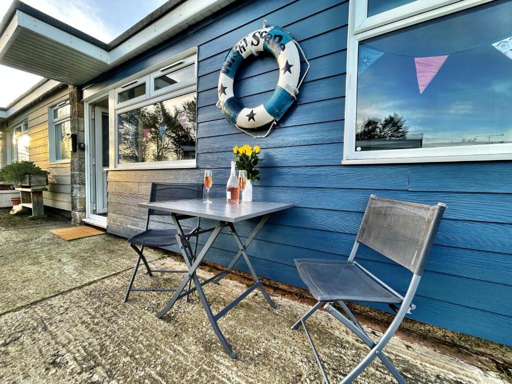 una mesa y dos sillas frente a una casa en Wight Waves Holidays, en Sandown