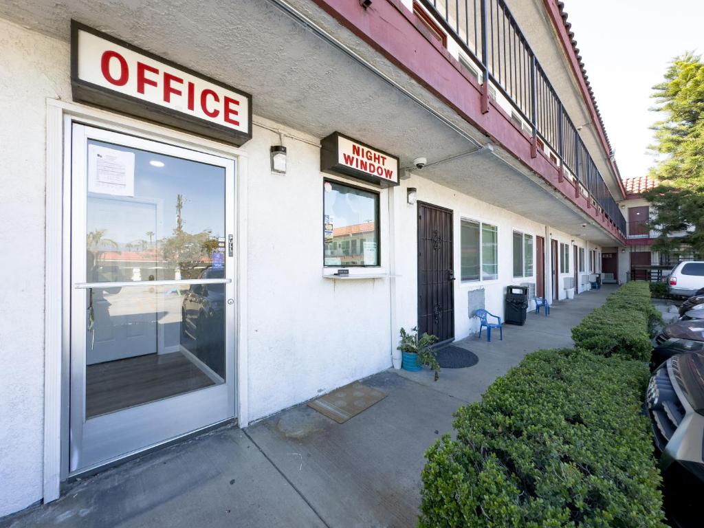 una señal de oficina en el lateral de un edificio en Courtesy Inn & Suites, en Rosemead