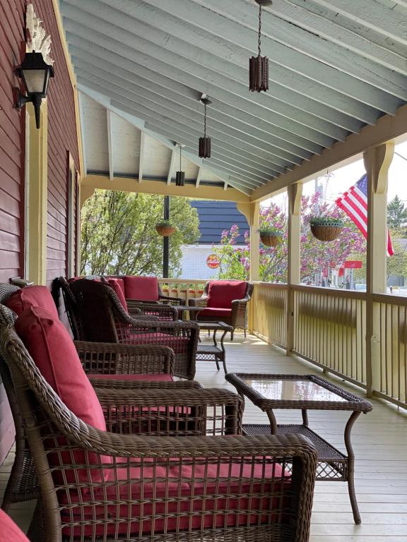een afgeschermde veranda met stoelen en een tafel bij Central House Inn in Bar Harbor