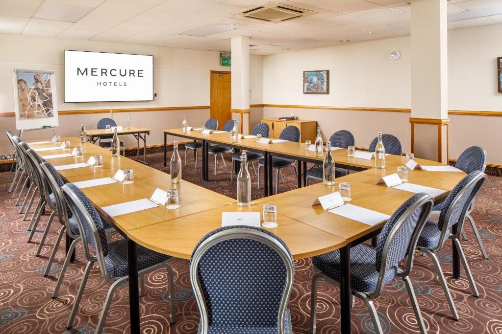 a large conference room with long tables and chairs at Mercure Glasgow City Hotel in Glasgow