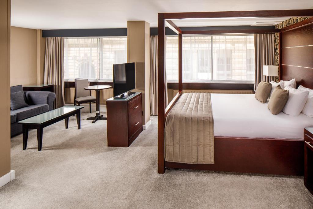 a hotel room with a bed and a living room at Mercure Glasgow City Hotel in Glasgow