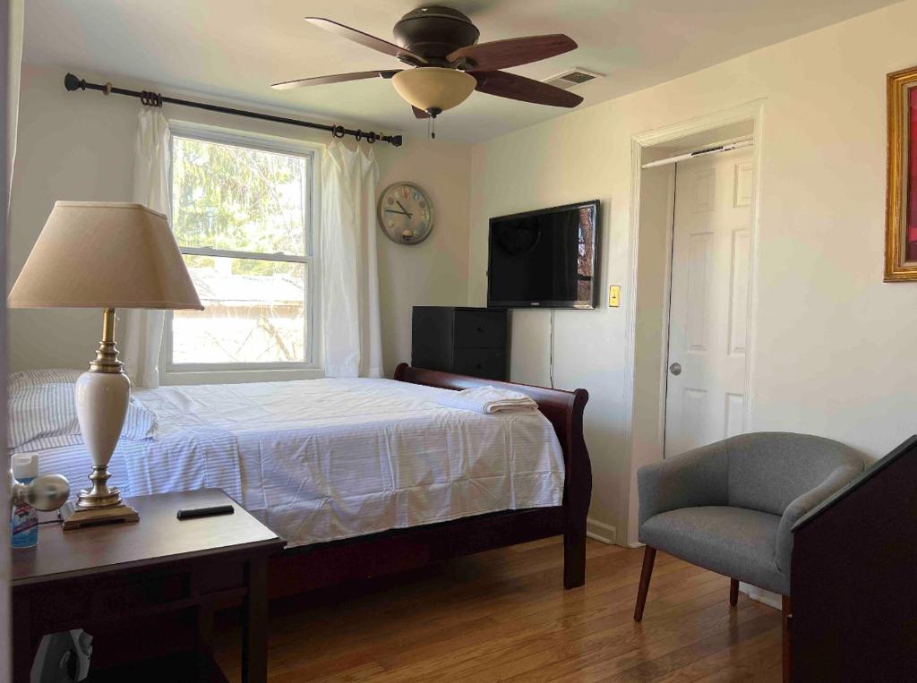 um quarto com uma cama, uma mesa e uma janela em Aloha of Falls Church em Falls Church