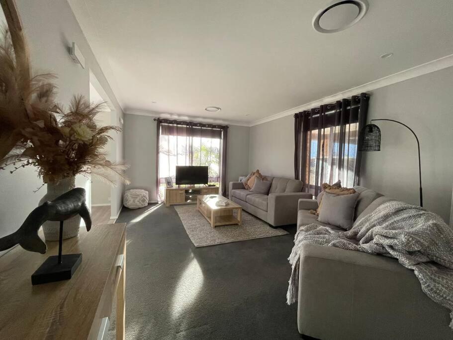 a living room with a couch and a table at 'Anchor Management' Recently Renovated 3BR / 2BTH in Nelson Bay