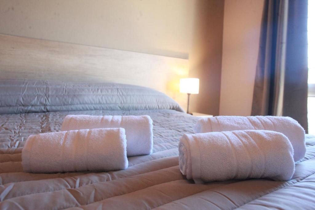 Un dormitorio con una cama con toallas blancas. en Departamentos Los Sauces en San Rafael