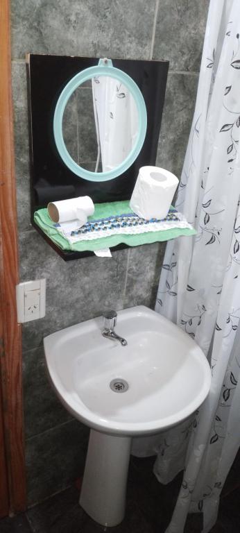 y baño con lavabo blanco y espejo. en Cabaña Tamanduá en Puerto Iguazú