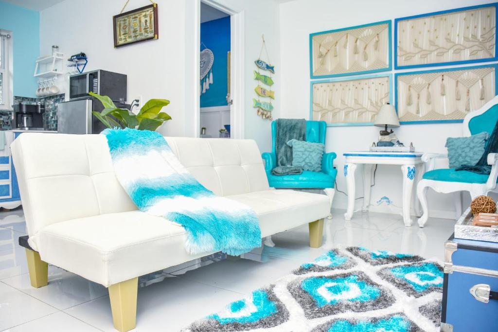 un soggiorno con mobili bianchi e dettagli blu di Miami Boho Beach Place a Hialeah
