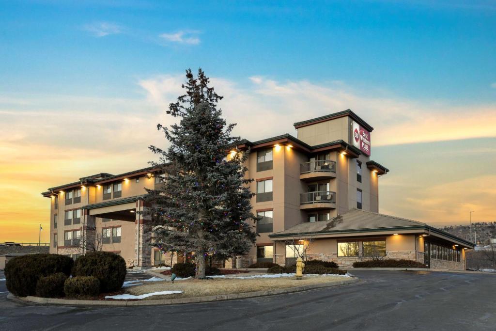 a hotel with a christmas tree in front of it at Best Western Plus Castle Rock in Castle Rock