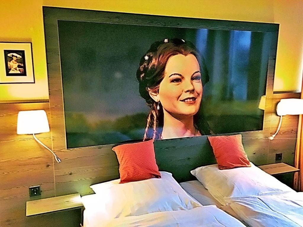 ein großes Bild einer Frau an einer Wand über einem Bett in der Unterkunft Retro - Art - Hotel Lünen in Lünen