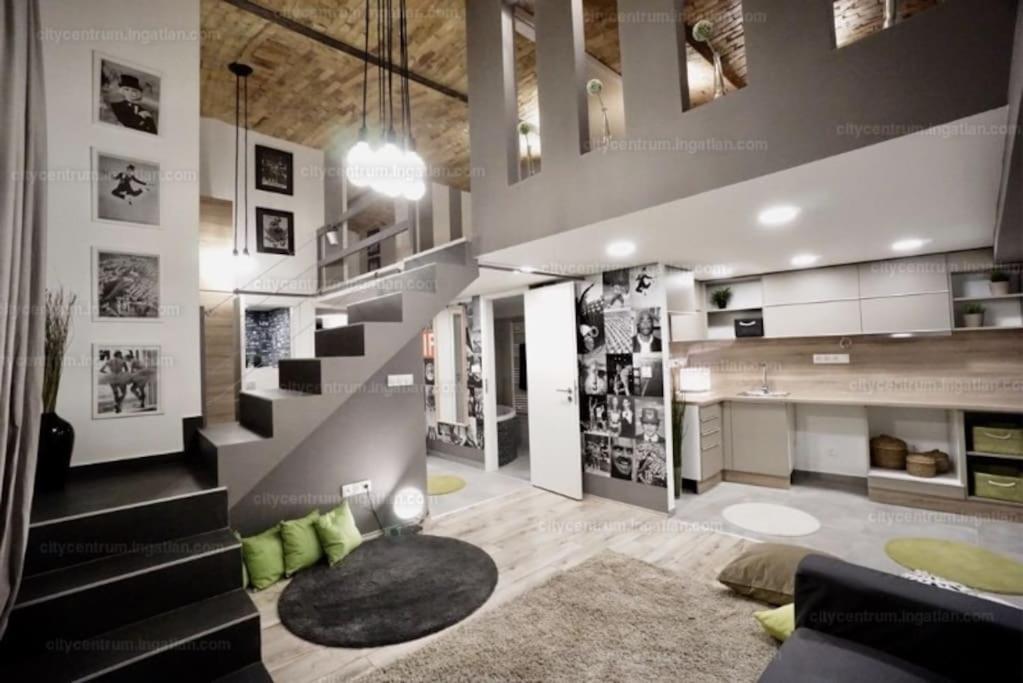 sala de estar con escalera y alfombra en Csengery Apartment en Budapest