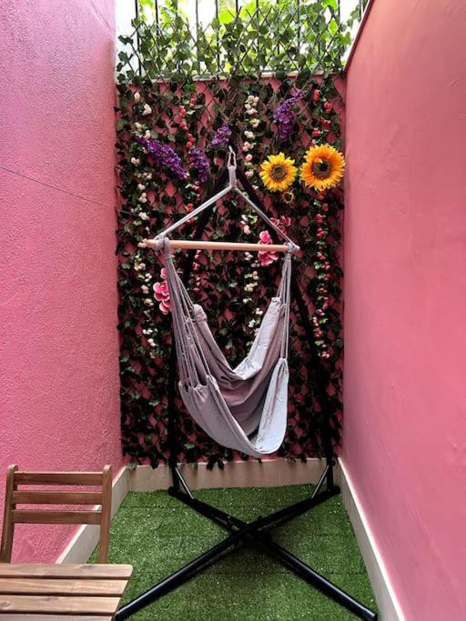 a hammock is hanging on a wall with flowers at Artistic Digital Getaway - Patio & GREAT Location! in Lisbon