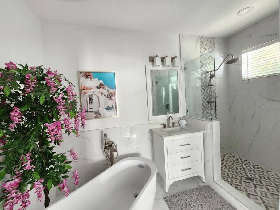 uma casa de banho com uma banheira, um lavatório e um espelho. em GreenLinks Golf View Villa Flamingo at Lely Resort em Naples