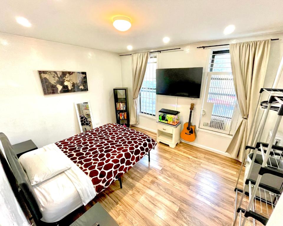 a bedroom with a bed and a flat screen tv at Big Bedroom Best Location ! - Free Parking and first floor in Queens