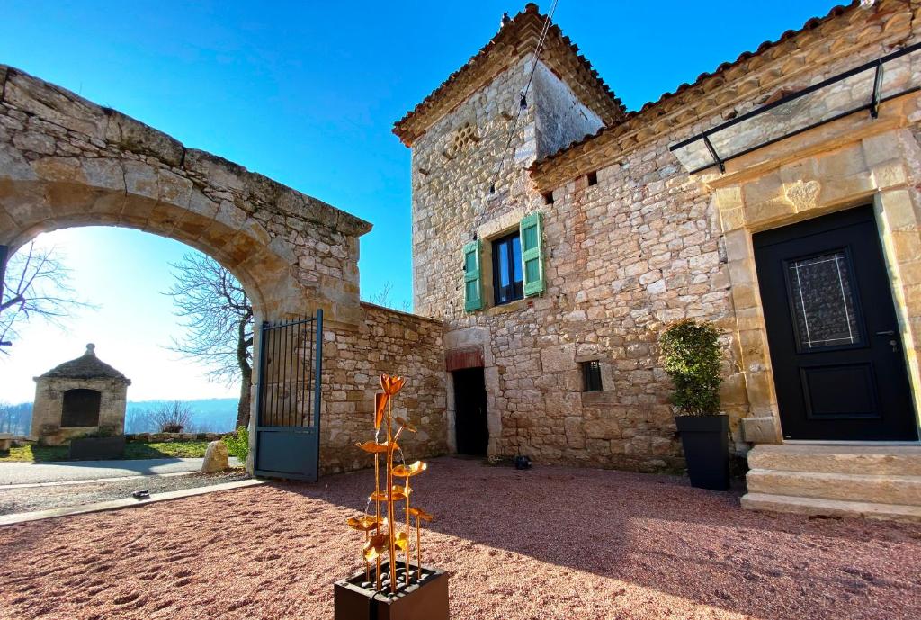 a large stone building with a gate and an archway at DOMAINE DE LEJOS - Portes d'Albi in Lamillarié