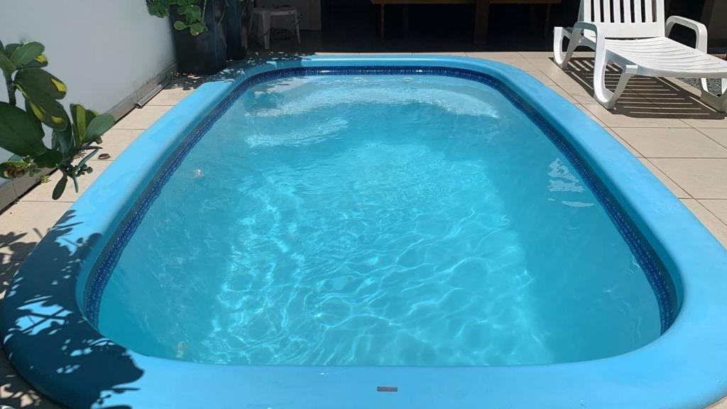 una piscina azul con una silla blanca. en Sobrado com piscina em Mariscal Rutilio N125, en Bombinhas