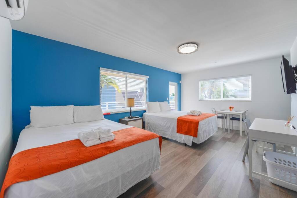 1 dormitorio con 2 camas y pared azul en The Mariner Suites #41, en Hollywood